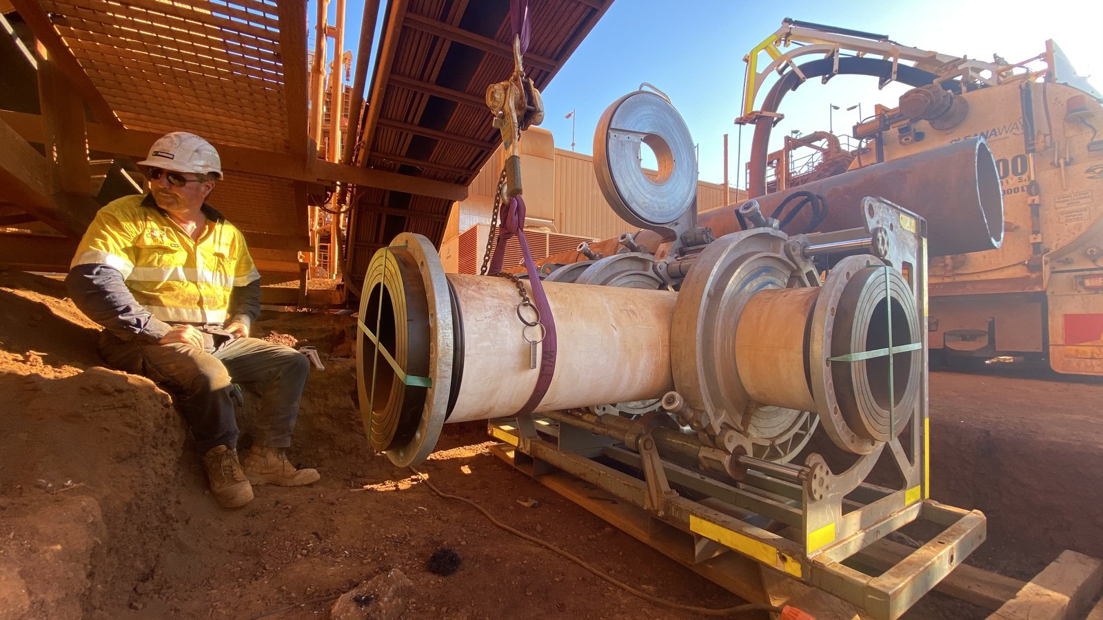 WA Plumbing technician operating a large-bore poly pipe butt-welding machine on a mine site